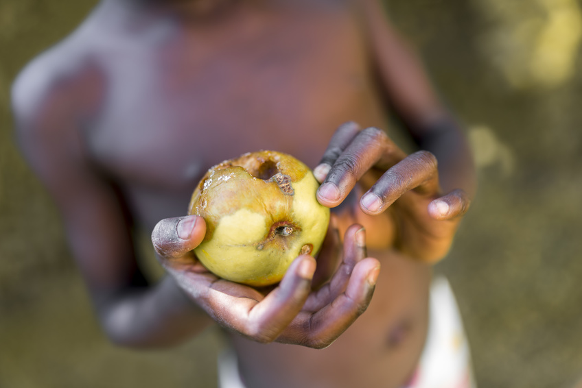 Black child holding rotten apple